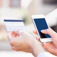 This photo of someone using a gift card to make a purchase on a smartphone demonstrates the gift card school fundraising idea.
